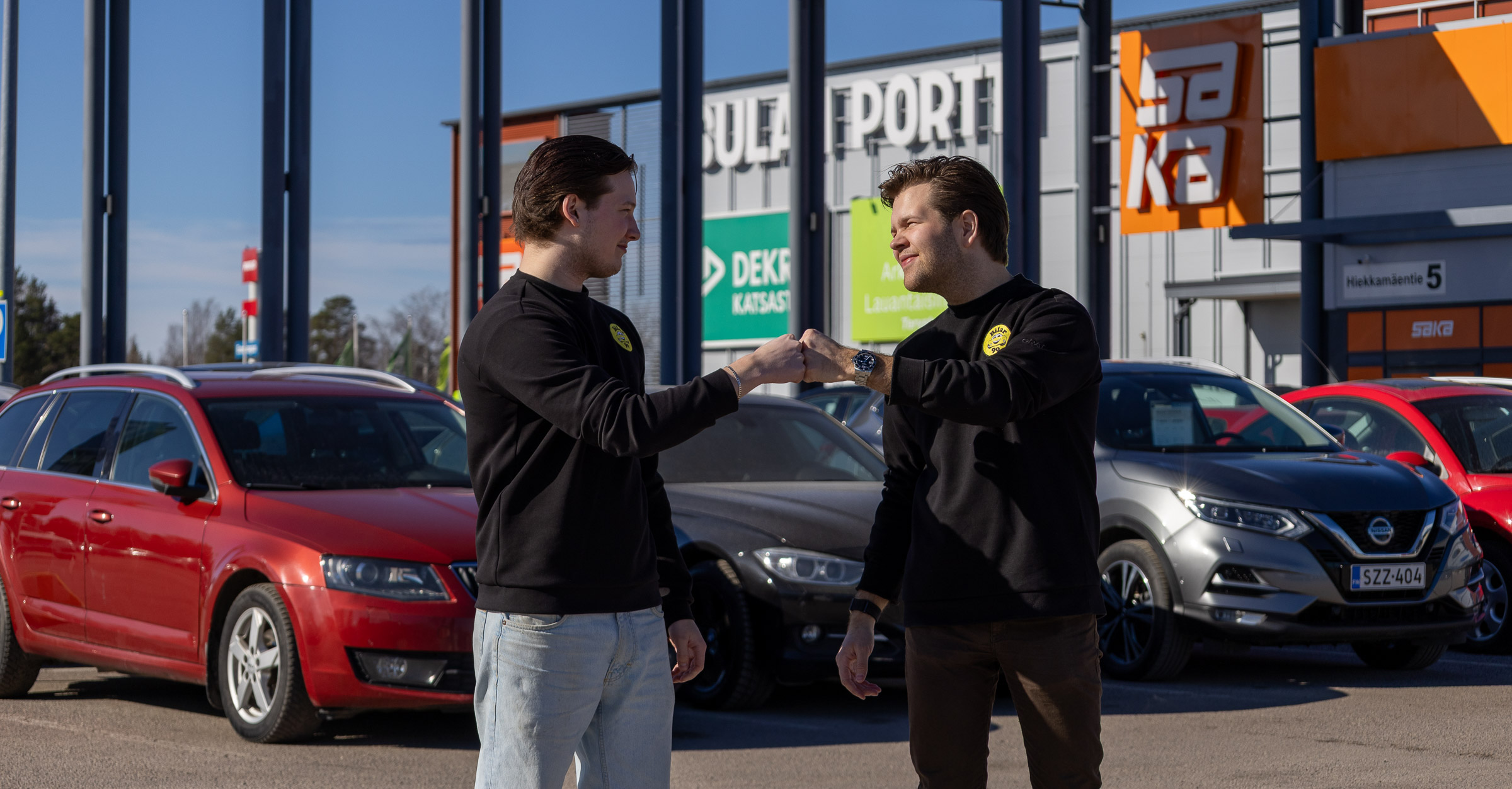 Kuvassa Bilarin automyyjä Daniel Kilpeläinen (vas.) ja myyntipäällikkö Johannes Peltoniemi Tuusulan Sulan Portin edustalla. Taustalla kilpailevien autoliikkeiden tiloja samassa kiinteistössä.